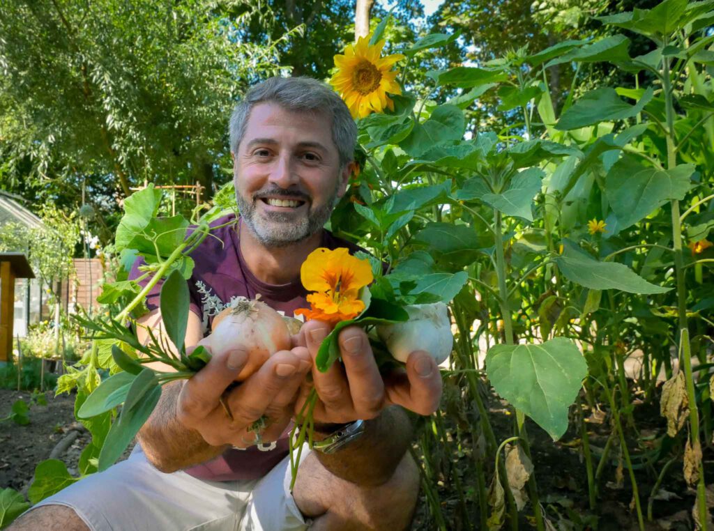 Projektleiter Ioseb Kartlelishvili zeigt einen Strauch aus gepflückten Kräutern
