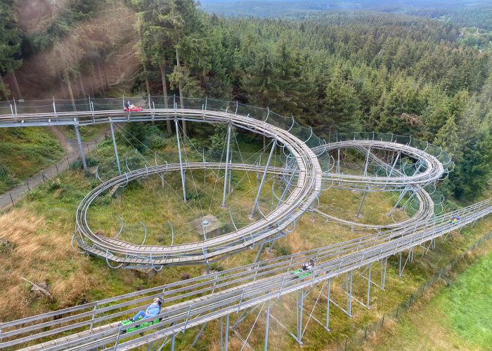 Betreute Reise Harz: Blick von oben auf die Sommerrodelbahn. Hintergrund Harz-Panorama